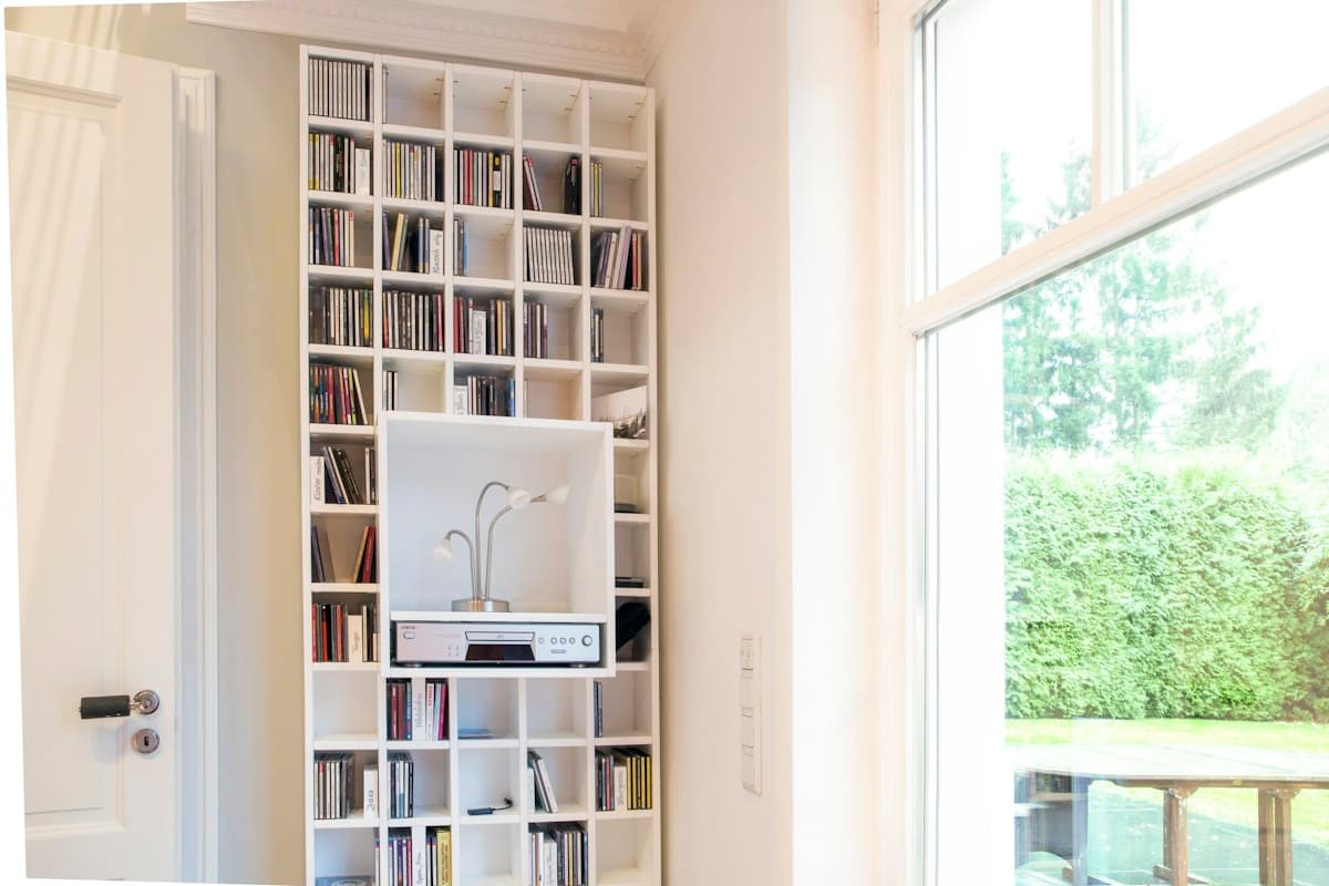 White wooden bookshelf near a window